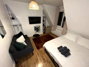 Relax in this cozy retreat with a large bed, sofa, and potted plant.