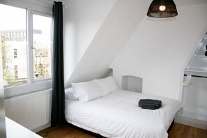 Cozy retreat with a single bed, headboard, and natural light pouring in through the window.