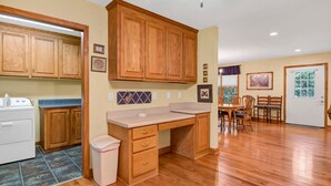 Una cocina con armarios de madera, una encimera y un cubo de basura.