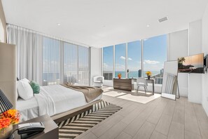 A modern hotel room with a large bed, a desk, a chair, a TV, and a view of the city. - Dream Penthouse at Hyde Hollywood  (Hollywood)
