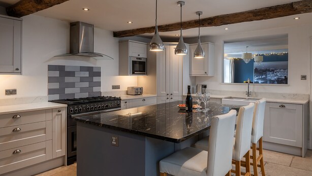 A modern kitchen with a central island, stainless steel appliances, and pendant lighting.