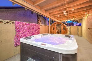 A hot tub in an outdoor setting with a decorative flower wall and wooden structures in the background. - Oasis near STRIP-Lap Pool, Spa, Sauna, Poker, Deck (Las Vegas)
