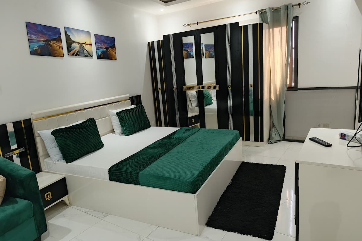 A modern bedroom with a bed, bedside table, and a desk.