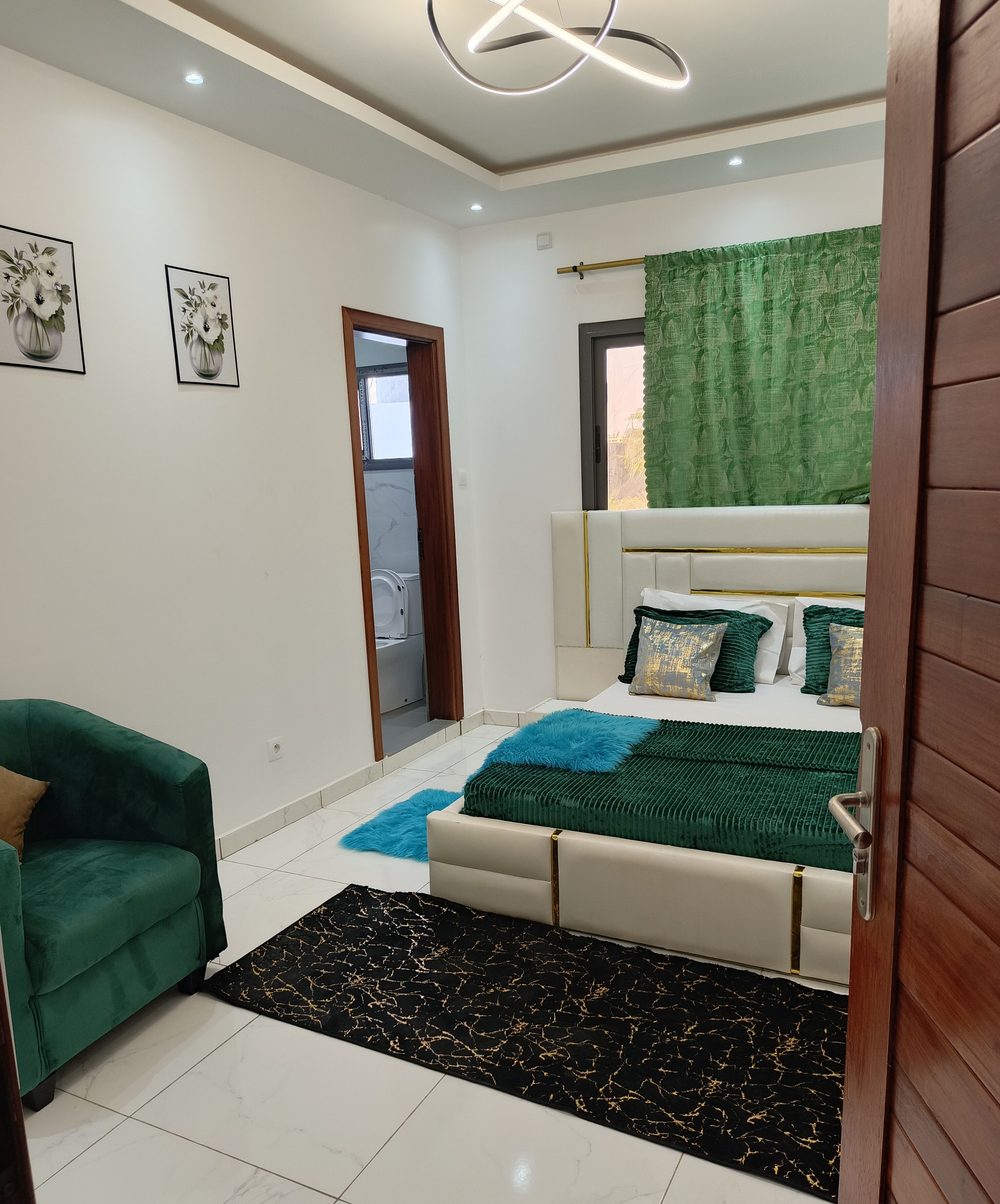 A modern bedroom with a bed, green and white sofa, and a small table.