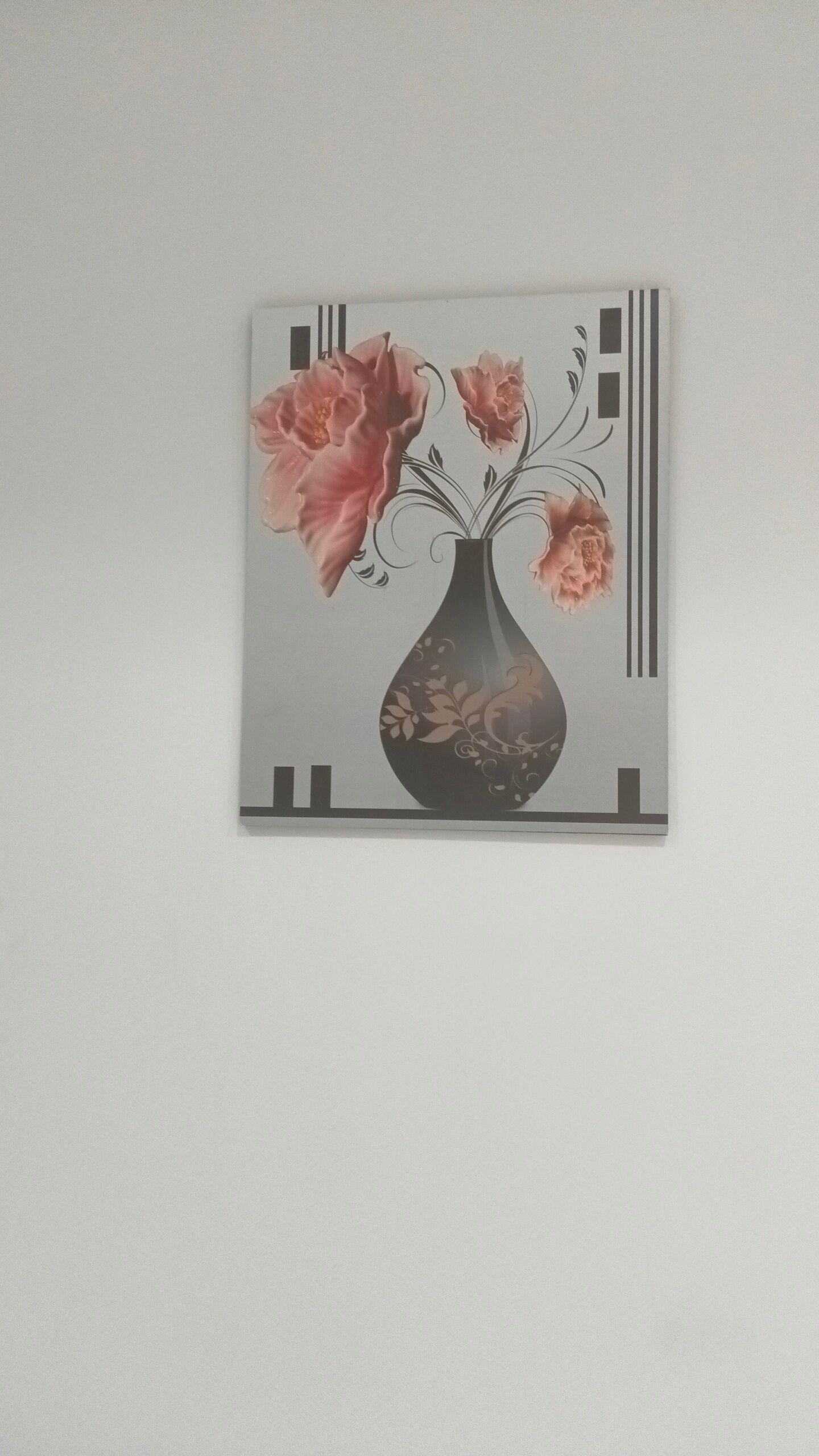 Een wanddecoratie van een vaas met bloemen.