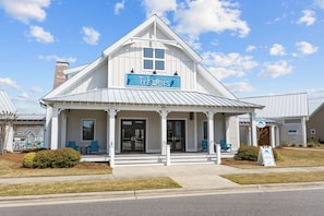 A white building with a sign reading 'Traiders' and a covered porch with chairs.