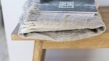 A wooden table with a folded cloth and a book on top.