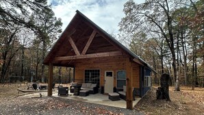A lodge with a covered patio, outdoor seating, and a basketball hoop.