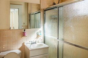A bathroom with a toilet, sink, and mirror. - Steps from the ocean minutes from Boston Beach house for rent 10% off first week (Winthrop)