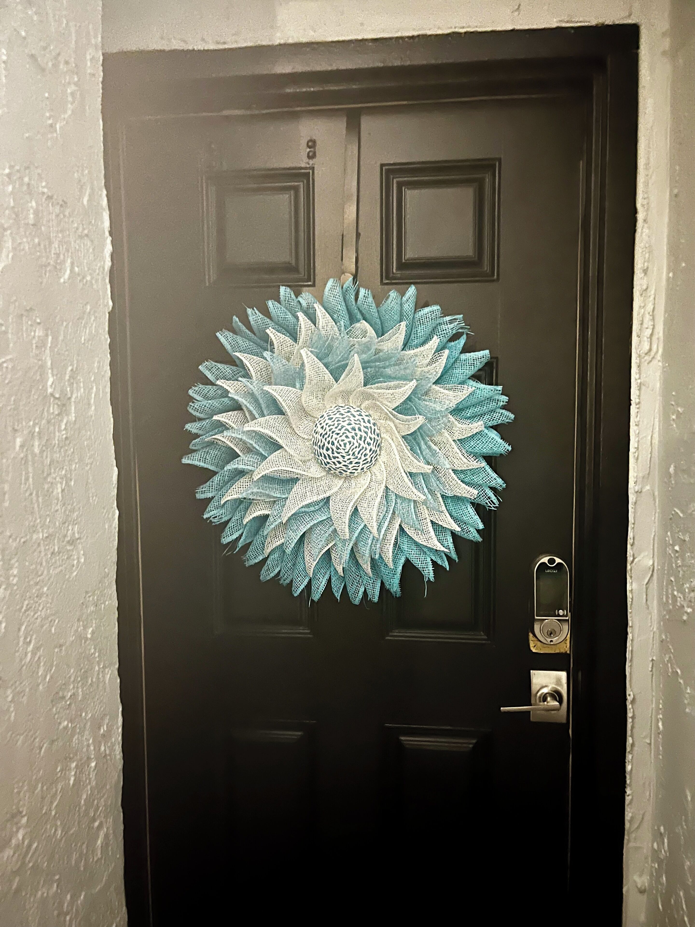 Une porte noire ornée d’un motif circulaire décoratif.