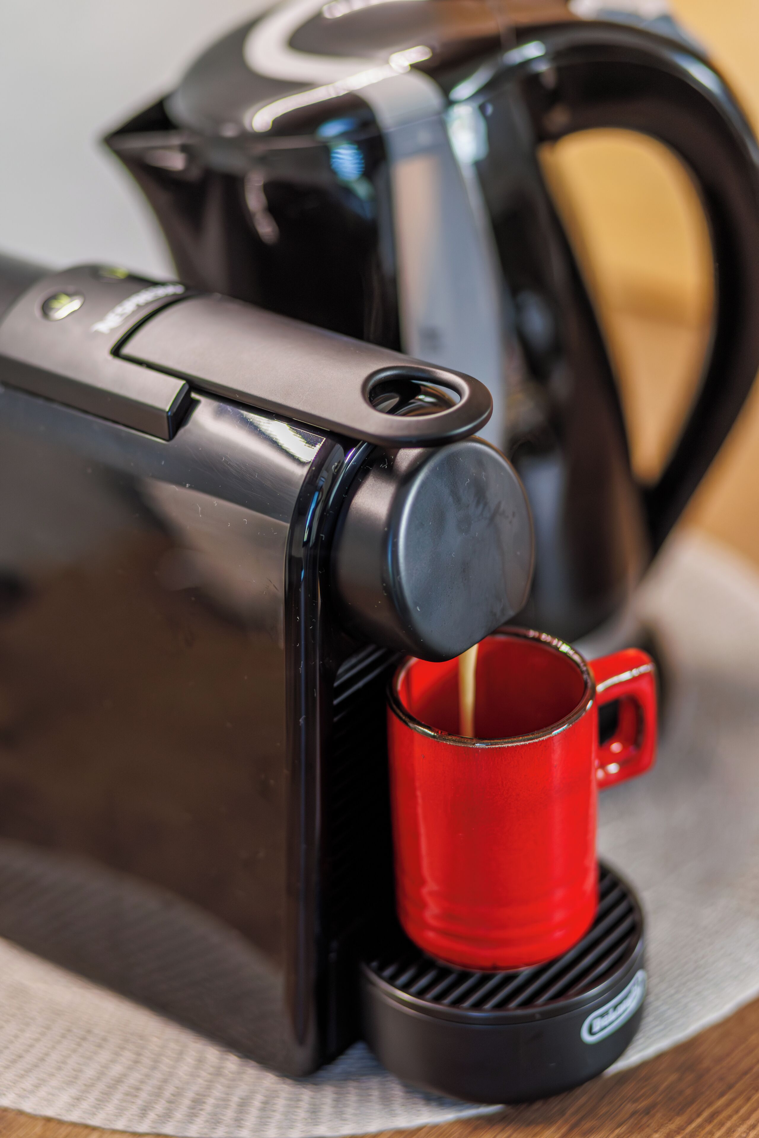 A coffee maker with a red mug.