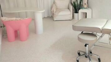 Simple, functional space with a white chair, side table, and desk.