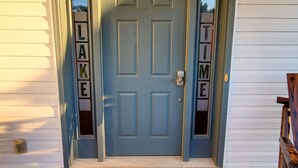 Une porte d’entrée bleue avec les mots « LAKE TIME » inscrits sur les panneaux de verre.