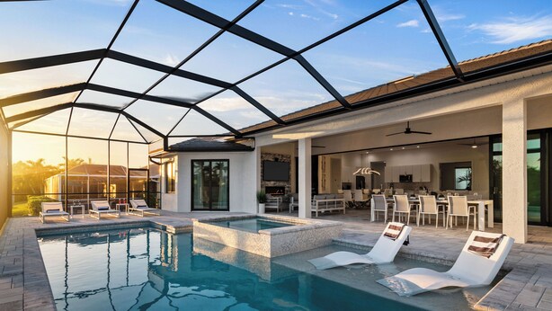 An indoor swimming pool with lounge chairs, a dining area, and a kitchen. - Intervillas Florida - Villa Penelope (Cape Coral)