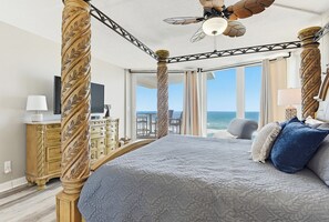 A four-poster bed with a ceiling fan, a television, and a view of the ocean. - 705 is a Cozy 2-bedroom 7th floor condo in beautiful Daytona Beach Shores. (Daytona Beach)