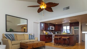A spacious living area with a large sofa, a wooden coffee table, and a ceiling fan. - Charming 2-bedroom condo with AC and WiFi in delightful Palm Desert (Palm Desert)