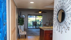 A modern kitchen with a central island, wooden cabinets, and a ceiling fan. - Charming 2-bedroom condo with AC and WiFi in delightful Palm Desert (Palm Desert)