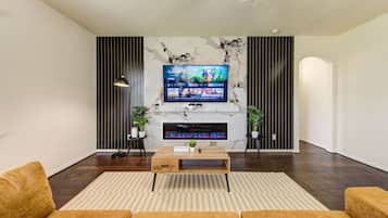 Smart-tv, eldstad och ett bordtennisbord