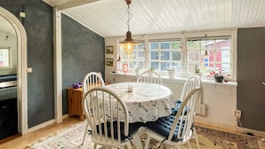 A dining area with a round table, white chairs, and a patterned rug. - 4 Person Holiday Home in Monsteras (Monsteras)