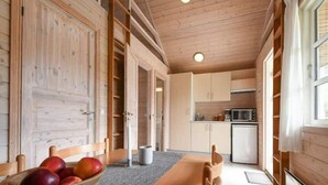 Eine moderne Küche mit Holzausstattung, einer Mikrowelle und einem Essbereich mit Tisch und Stühlen.