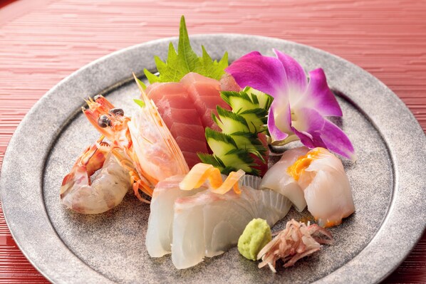 A plate of sushi with various types of fish and garnishes. - Yuyado Choseian (Shirahama)