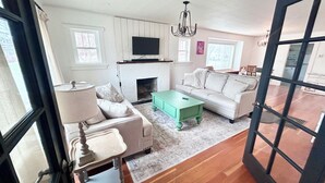 Ein Wohnzimmer mit Kamin, Sofa und Fernseher.