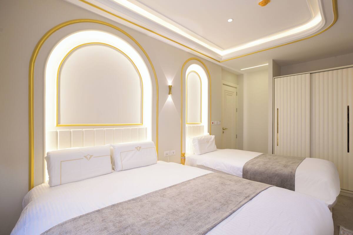 Ein Hotelzimmer mit zwei Betten, einem großen Spiegel und einem Kleiderschrank.