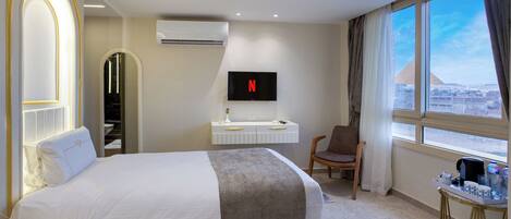 Une chambre d’hôtel avec deux lits, une télévision, un bureau, une chaise et une vue sur le paysage urbain.