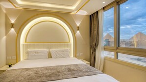 A hotel room with a large bed, a view of the pyramids, and a modern design. - Pyramids Plateau Hotel (Giza)