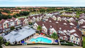 A residential area with multiple two-story houses, a swimming pool, and a covered patio area with umbrellas. - Spacious 5-bedroom townhome with AC, WiFi in wonderful Orlando (Orlando)