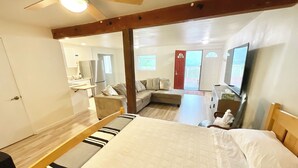 A bedroom with a bed, a wooden headboard, a ceiling fan, and a large mirror. - Spacious Sequoia Park 5 bed 3 bath house w/ AC & WIFI in charming Three Rivers (Three Rivers)