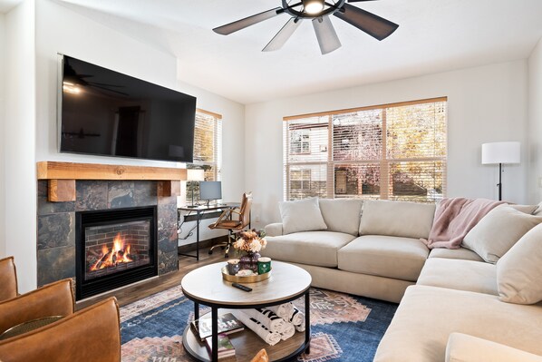 Een smart-tv, een open haard, boeken en een kantoor