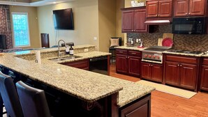 A kitchen with granite countertops, wooden cabinets, a built-in oven, and a microwave. - Spacious 5-bedroom house with AC, WiFi in charming Bluffton (Bluffton)