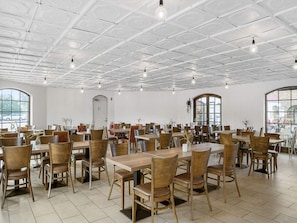 A spacious dining area with multiple tables and chairs, large windows, and a white ceiling with grid patterns. - 6 Person Holiday Park Home in Otterup (Otterup)