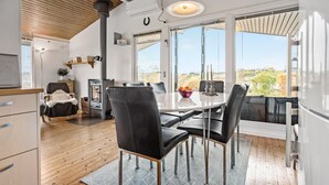 Una cucina moderna con un ampio tavolo da pranzo, sedie in pelle nera e vista sull'esterno.
