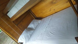 Een houten stapelbed met wit beddengoed.