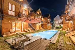 A wooden cabin-style hotel with a swimming pool, outdoor seating, and a staircase leading to the upper floors. - Anartha Resort Jimbaran (Jimbaran)