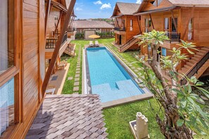 A wooden villa with a swimming pool, outdoor seating, and a staircase leading to the upper floor. - Anartha Resort Jimbaran (Jimbaran)