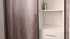 Um guarda-roupa com porta deslizante e uma divisória embutida com gavetas.