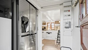 A kitchen with a stainless steel refrigerator, wooden cabinets, and a checkered towel hanging on the door. - Awesome home in Tim with WiFi (Tim)