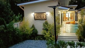 A modern house with a swimming pool, a well-lit exterior, and a framed artwork on the wall. - Saendee Pool Villa (Klaeng)