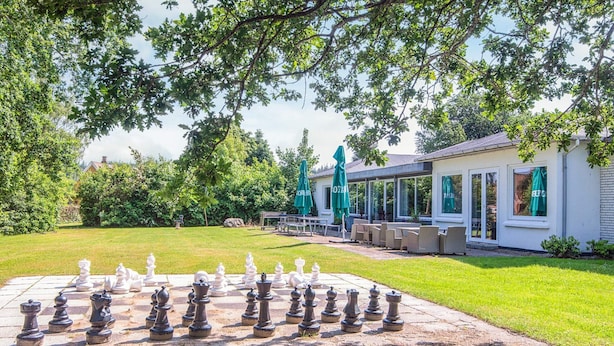 A chessboard set up outdoors with a building in the background. - Pretty Cabin in Camping Resort (Aabenraa)