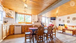 Un intérieur en bois comprenant un coin repas, une cuisine et un espace de vie.