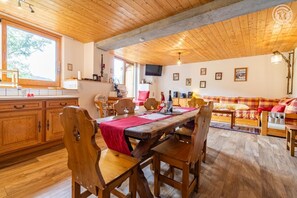Un intérieur rustique en bois comprenant un coin repas, une cuisine et un espace de vie.