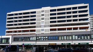 A multi-story building with a modern architectural design, featuring a central atrium with a grid-like pattern. - Küstenmuschel - Modern 1-room apartment, close to the beach, balcony, WLAN. Pets (Westerland)