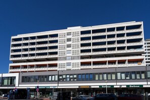 Ein mehrstöckiges Gebäude mit moderner Architektur, das ein zentrales Atrium mit einem gitterförmigen Muster zeigt.