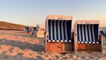 Strandkörbe mit den Nummern 2214 und 2213, vor einem Sandstrand und Dünen.