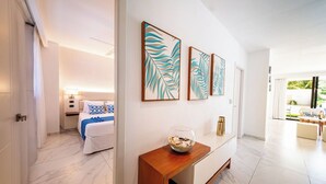 Een moderne hotelkamer met een bed, nachtkastje en kunst aan de muur.