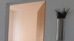 Une chambre à coucher comprenant un lit, une table de chevet et une étagère murale décorative.