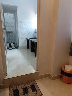 A bathroom with a sink, toilet, and a checkered floor. - Arnnapurna Hotels & Resorts (Jajapur)
